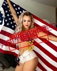 a cute blond exotic dancer in Houston holding an American flag up