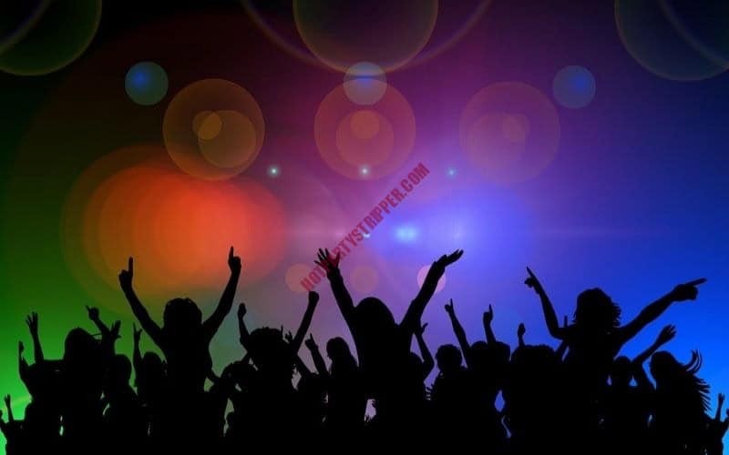 Silhouette of people at a party with their hands up