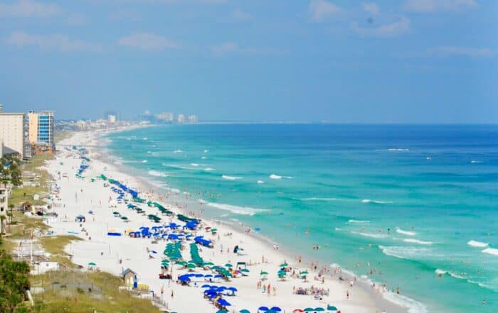 A beach with umbrellas and people on it.