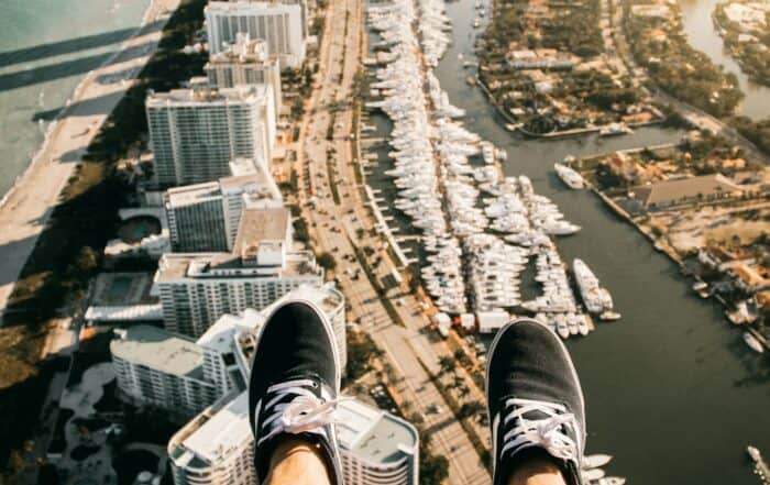 featured-image-1748979185 | Hot Party Stripper A person sitting on the edge of a building overlooking a city.