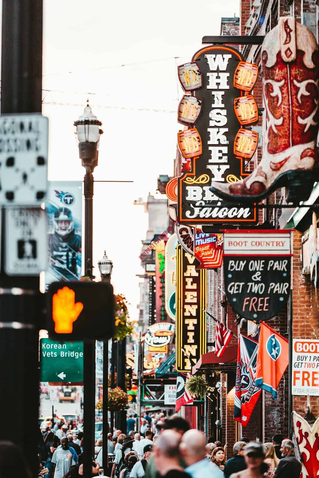 A busy city street in Nashville with many people walking and cars driving.