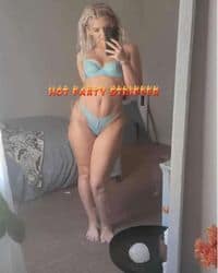 A woman in a bikini taking a selfie in front of a mirror.