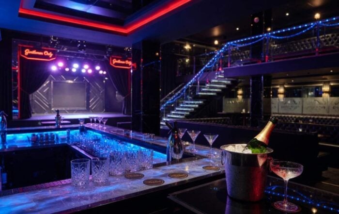 Upscale Manhattan gentlemen's club interior at night with neon lighting — Hustler Club NYC visitor guide by Hot Party Stripper